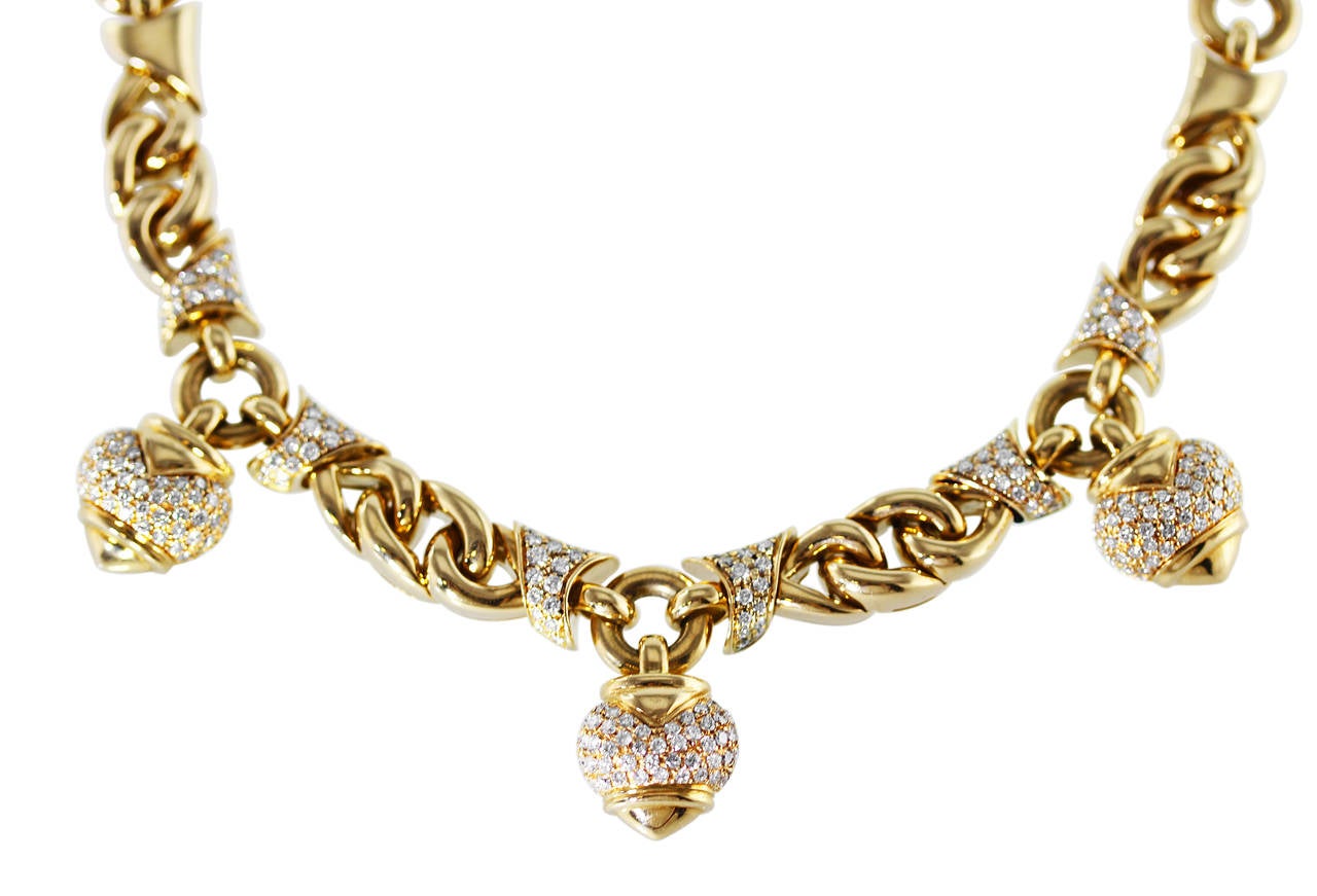An 18 karat yellow gold and diamond pendant-necklace by Bulgari, composed of various-shaped polished gold links supporting three heart-shaped pendants, set throughout with 330 round diamonds weighing approximately 5.00 carats, gross weight