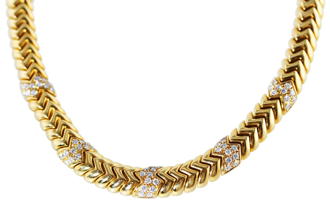 An 18 karat yellow gold and diamond 'Spiga' necklace by Buglari, Italy, designed as diagonal interlocking polished gold links accented by 5 sections set with 60 round diamonds weighing approximately 2.40 carats, gross weight 136.2 grams, length 15