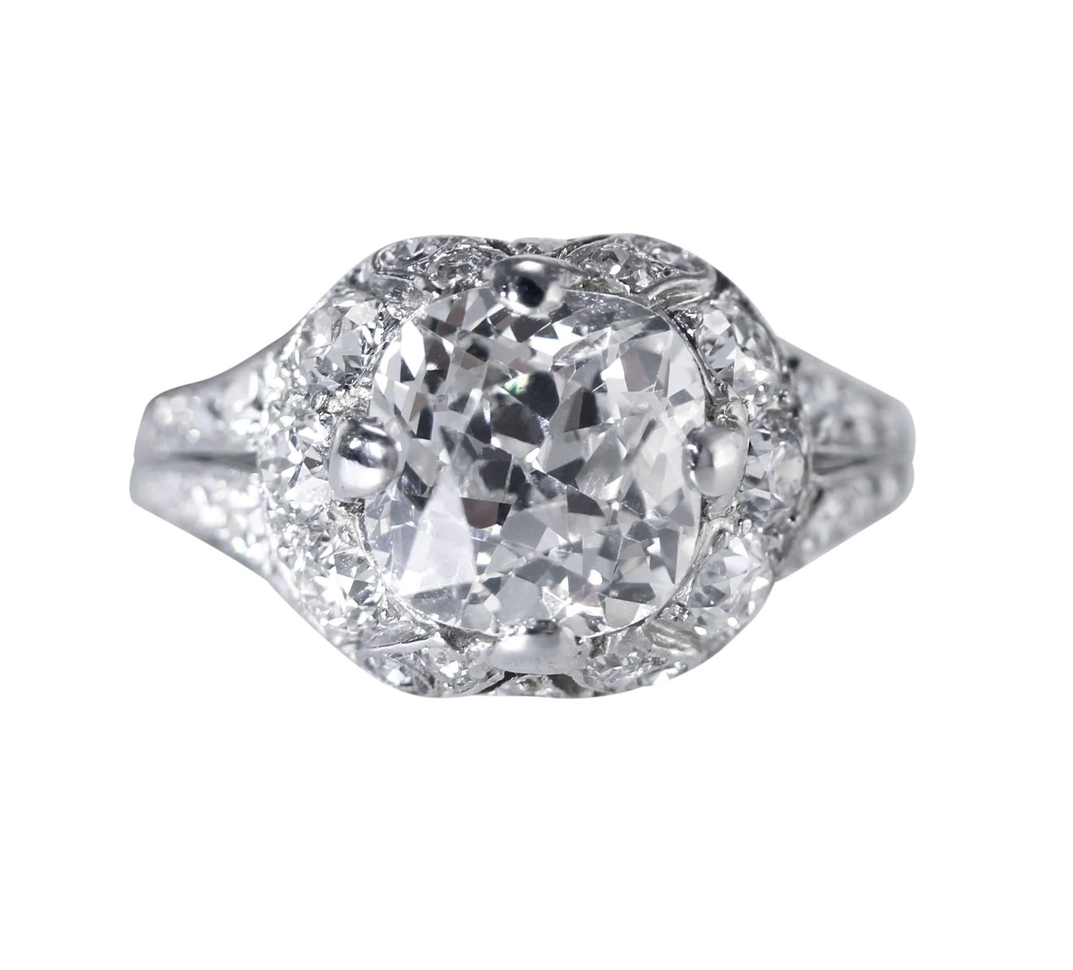 Genuine Edwardian platinum and diamond ring, set in the center with an old mine-cut diamond weighing 2.38 carats, within ornate openwork mounting set with 6 old European-cut and 26 single-cut diamonds weighing approximately 0.50 carat, gross weight
