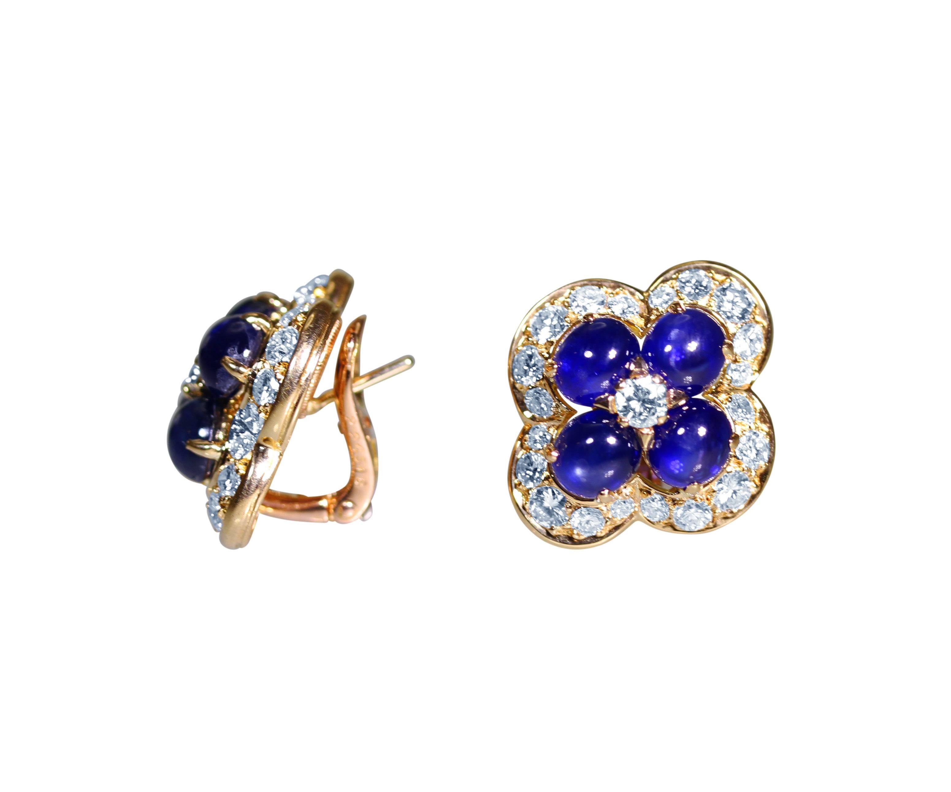 A pair of 18 karat yellow gold, sapphire and diamond earclips by Cartier, designed as flowerheads set in the center with 8 cabochon sapphires weighing approximately 8.00 carats, accented by 42 round diamonds weighing approximately 2.25 carats, gross