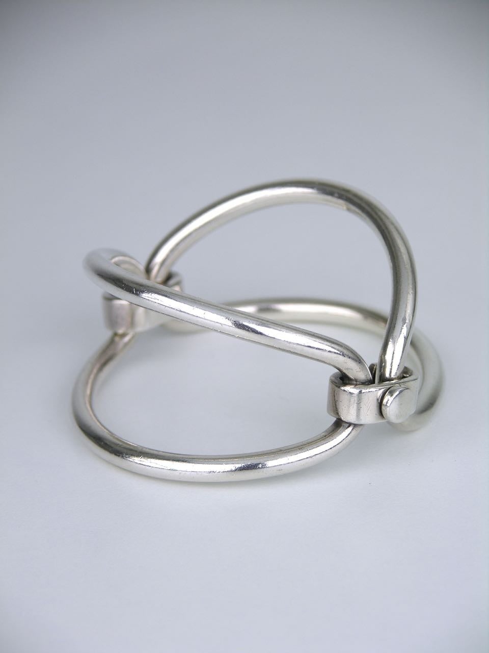 A rare design of two solid silver heavy gauge open oval links joined by a flat oval link - the flat smaller link is worn to the front of the wrist creating a minimalist bow like shape - with a screw closure to the back.

- marked for Gucci Italy