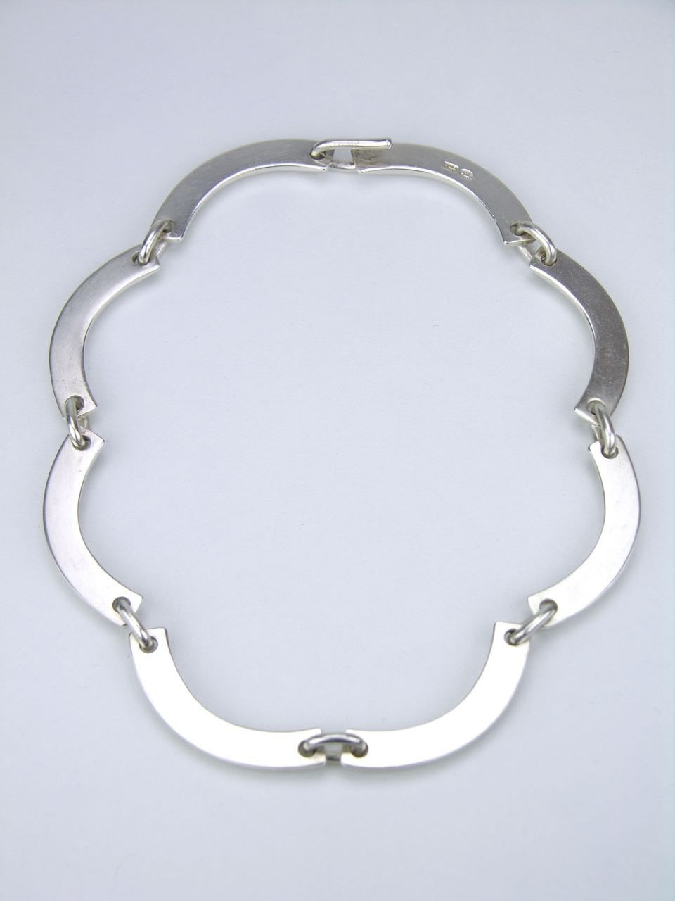 A heavy solid silver segmented necklace made up of eight curved links of a D profile bar motif joined with oval links and a concealed hook closure - marked with post 1945 marks for Georg Jensen of Copenhagen and designed by Hans Hansen

- total