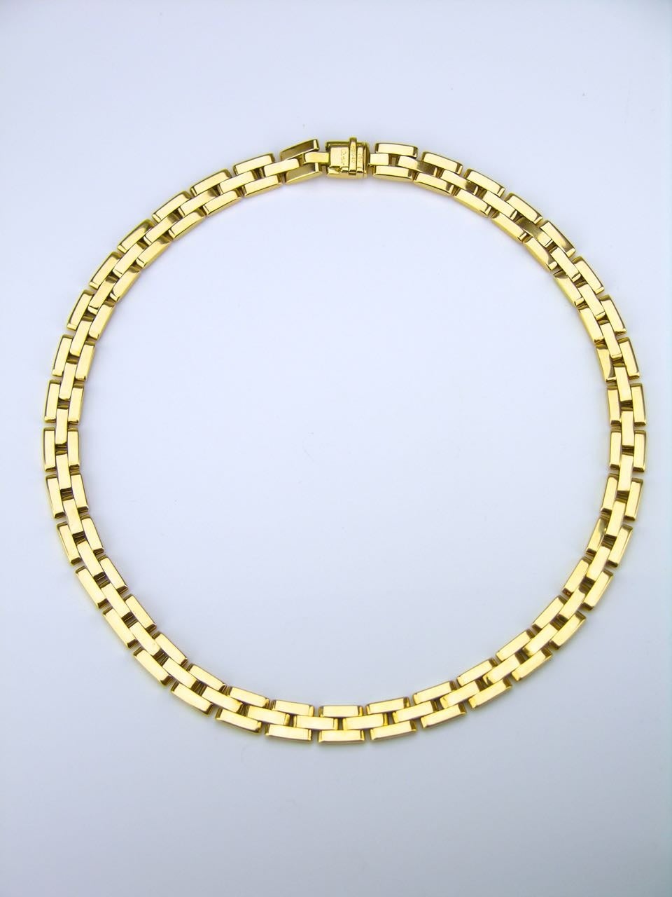 A three row gatelink style flat collar necklace in solid 18k yellow gold with a concealed safety catch.  Each link is gently domed with a flat back. The quality and weight of this elegant piece is all you would expect from one of the best jewellery