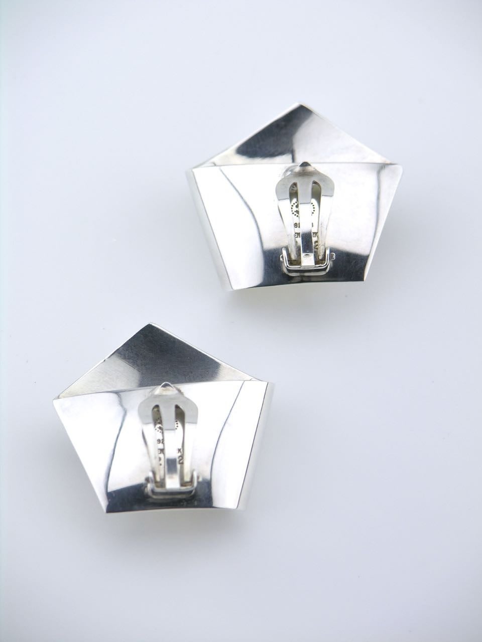 A pair of solid silver folded pentagon shape clip earrings by Georg Jensen - each earring consisting of a loosely folded ribbon that forms a pentagon shape with a clip back fitting 

- marked with post 1945 marks for Georg Jensen of Copenhagen and