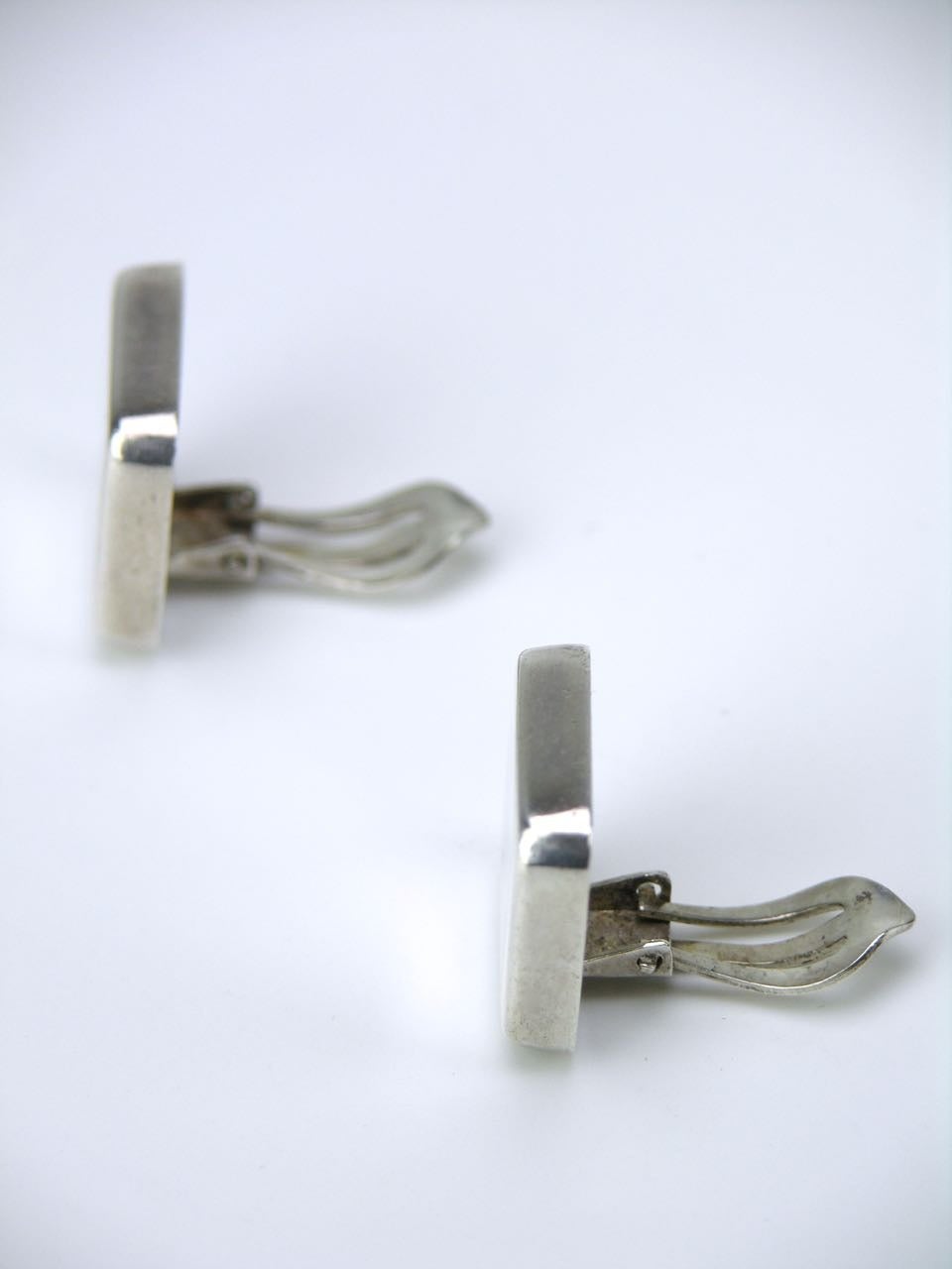 A pair of square clip earrings by Georg Jensen - a hollow square tablet of silver on a clip back 

- marked for post 1945 marks for Georg Jensen of Copenhagen
- design number 191 by Astrid Fog 
- total weight 11.9grms 
- dimensions of face 18mm