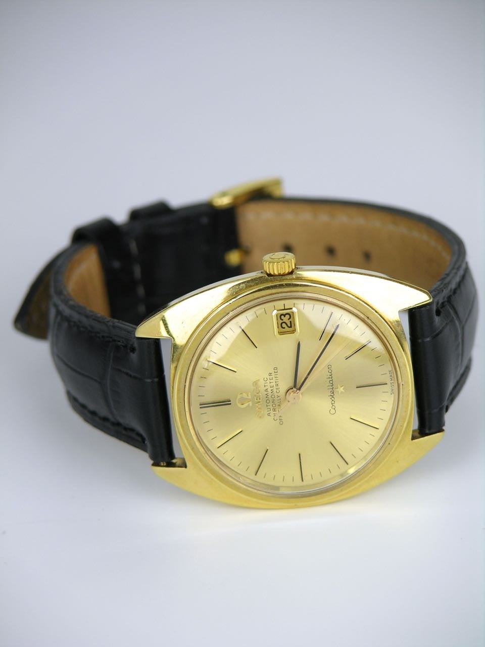 A 18ct gold mens Omega constellation wristwatch

- solid 18k yellow gold case  
- black leather band with omega rolled gold clasp 
- solid 18k yellow gold face with baton markers 
- 34mm diameter 
- automatic movement 
- calibre 564 
-
