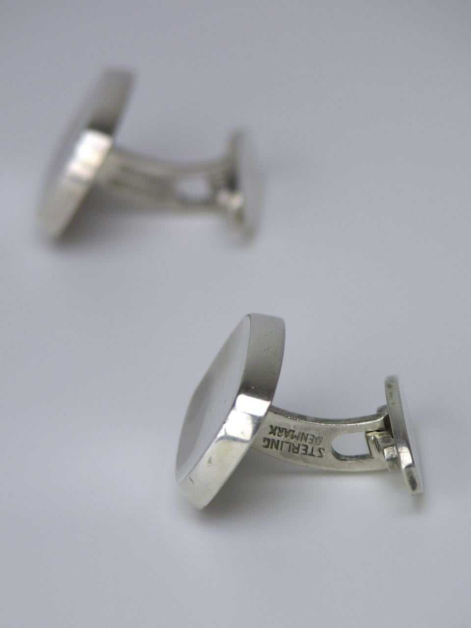 A pair of solid silver concave lozenge shape cufflinks by Bent Knudsen each cufflink consisting of a thick concave lozenge shape tablet with a bevelled edge on an arched oval toggle back fitting. 

- Signed Bentk for Bent Knudsen of Denmark 
-
