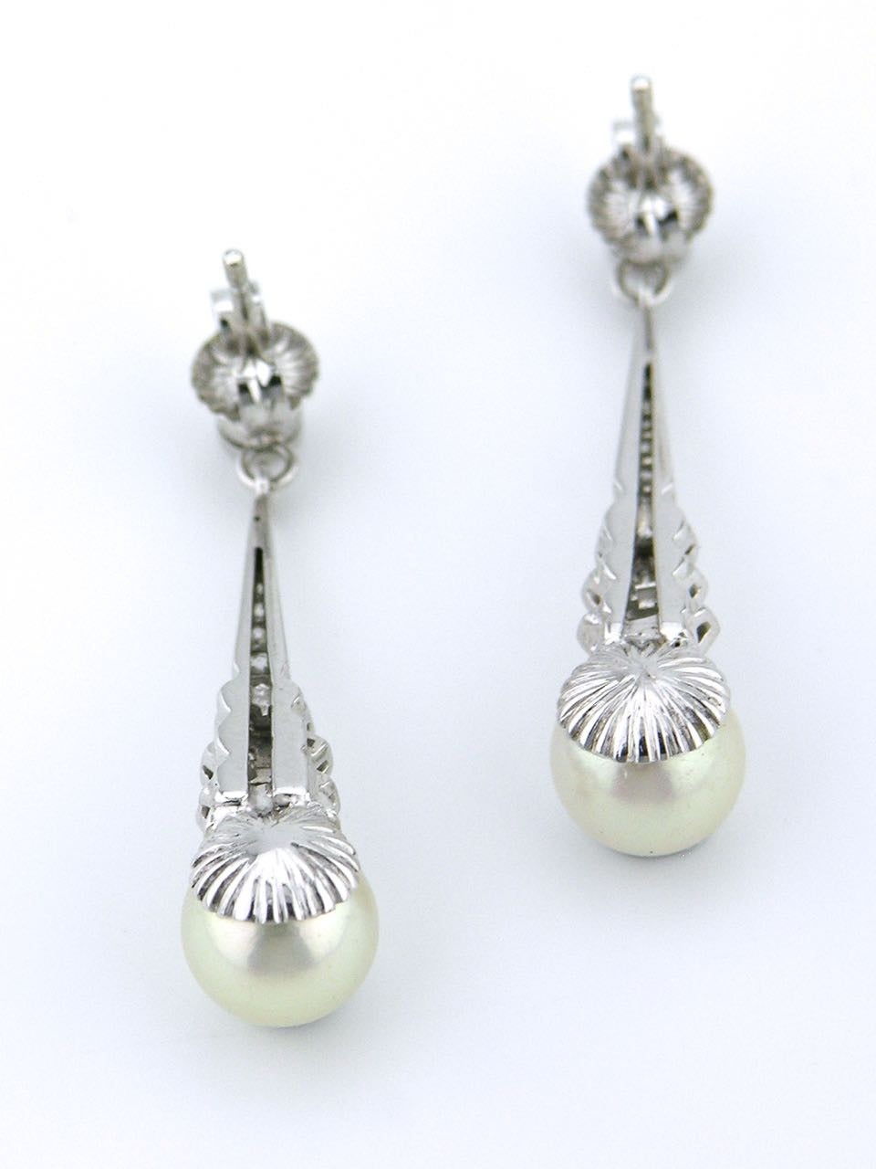 A pair of white gold pearl and diamond drop earrings - each earring consisting of a bezel set old cut diamond above 14 single cut diamonds above an 8mm cultured pearl set in 18k white gold

- total weight of diamonds 30 = 0.50ct G-H/VS-SI  
-