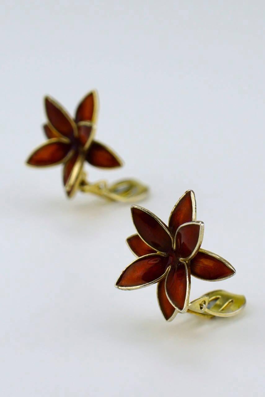 A pair of solid silver red enamel and modernist flower design clip earrings - each earring consisting of a three dimensional flower shape with red enamel and clip fittings 

- total weight of the pair 8.2grms 
- diameter 20mm
- c.1965 Norway