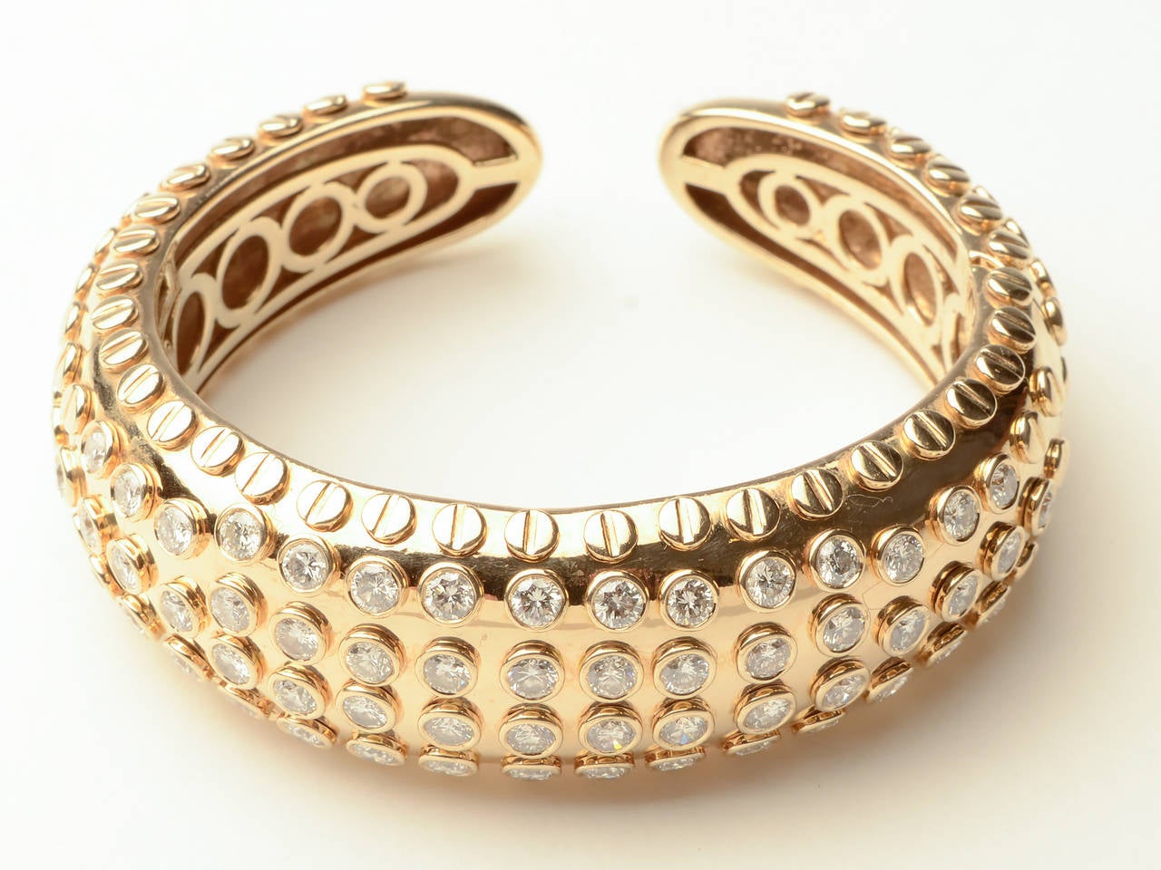 Stunning and unusual cuff bracelet by Sonia B. It is filled with more than 5 carats of diamonds that are surrounded by raised gold circles.  It has a clever invisible hinge so it is easy to slip on and fits a variety of wrist sizes. The inner
