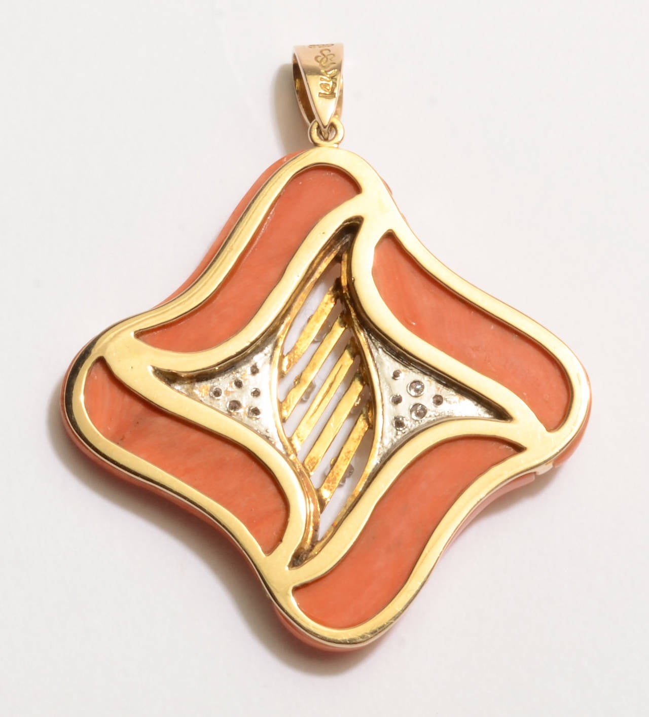 Curved edges of the coral and interior gold design make this  pendant especially graceful and unusual. Four diamonds in the interior follow through the pave settings on the sides. It measures 1 5/8