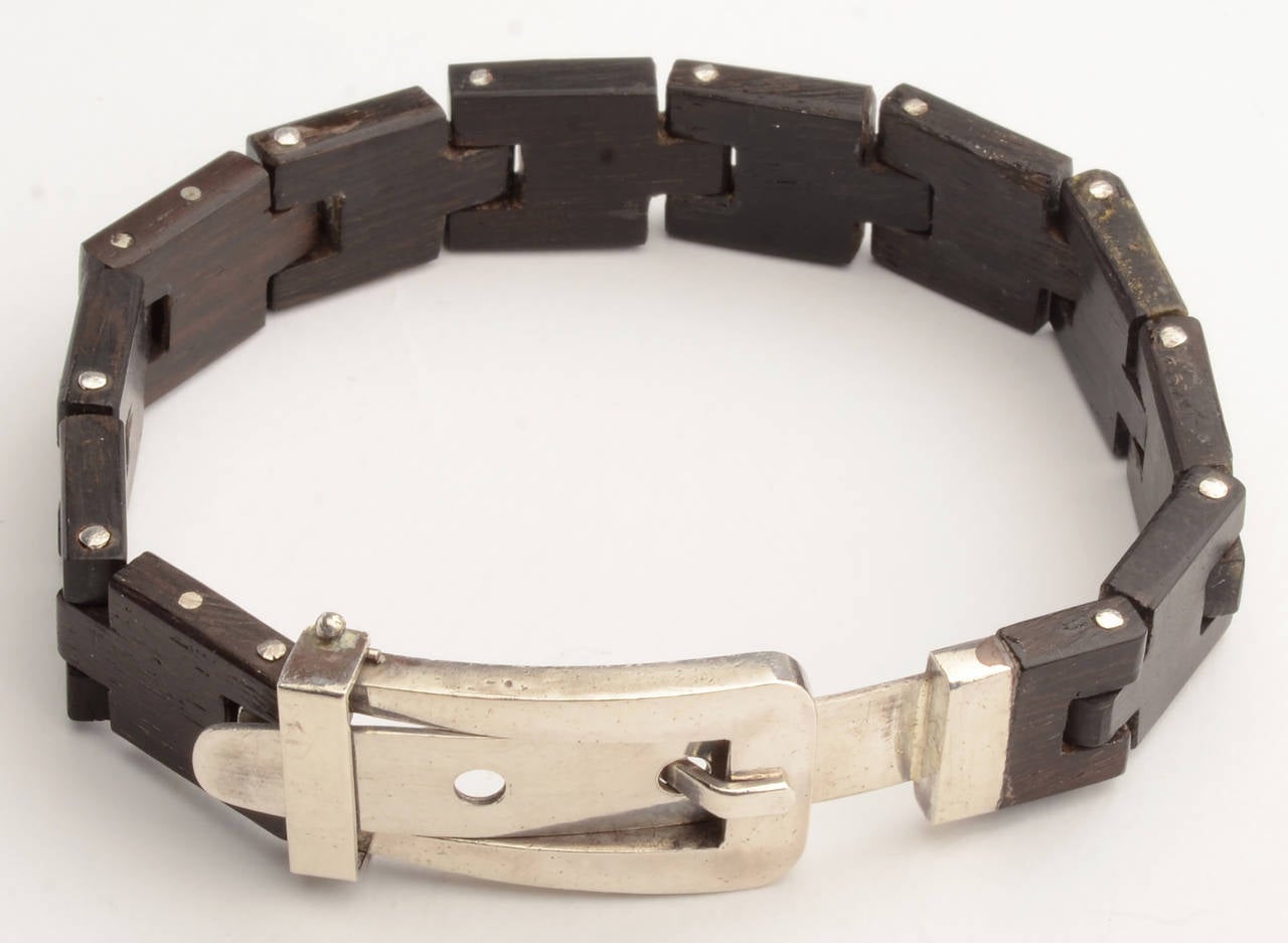 Most unusual wood and sterling  buckle bracelet by silver master William Spratling.The body of the bracelet is interlocking wood links with a buckle of silver.Two holes in the buckle allow for it to fit a variety of wrist sizes. The length can be