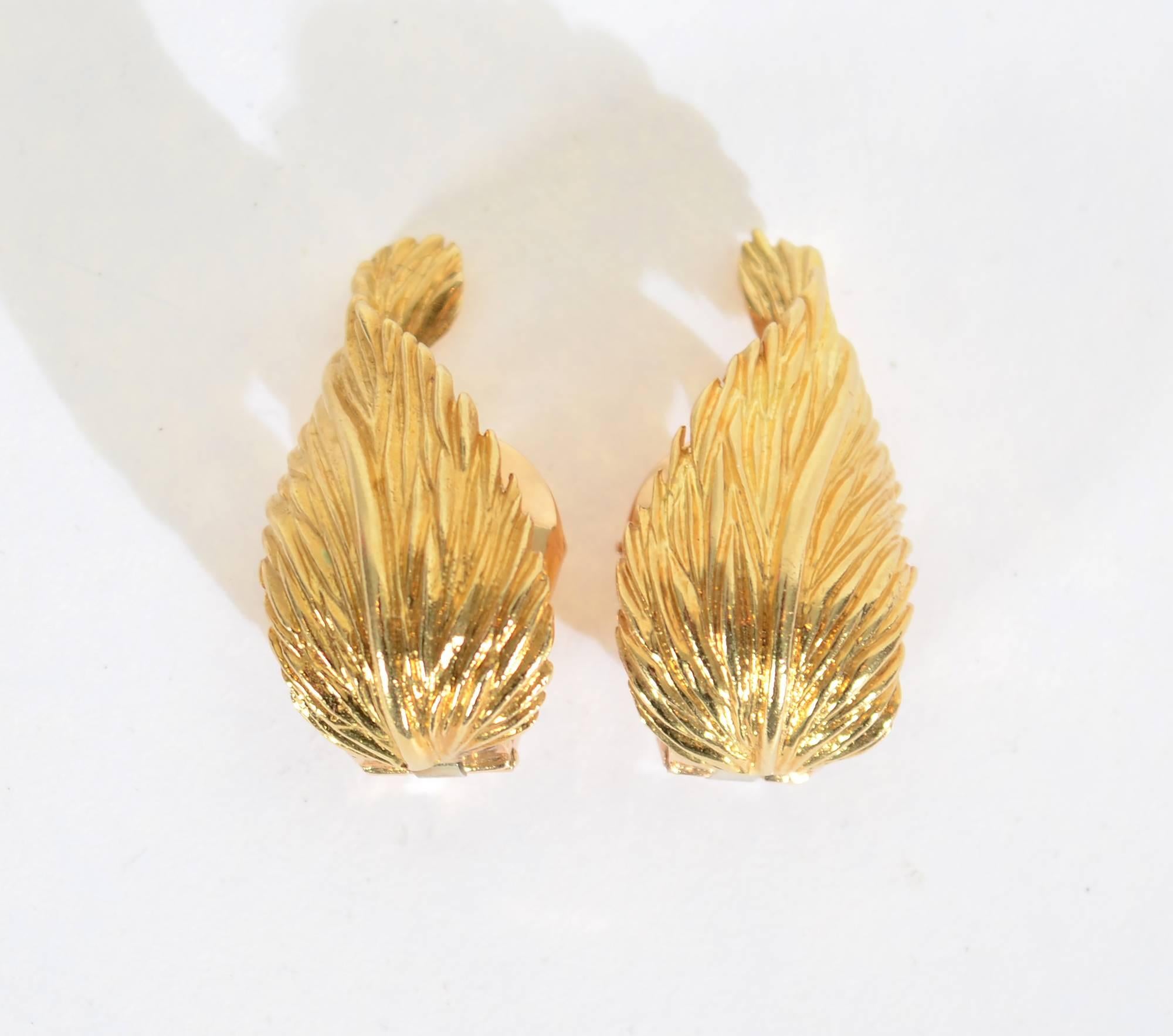 Graceful 18 karat gold earrings by Van Cleef and Arpels in the form of an undulating leaf. They are nicely textured. Measurements are 1 inch in length and 9/16" at the widest. Clip backs can be converted to posts.