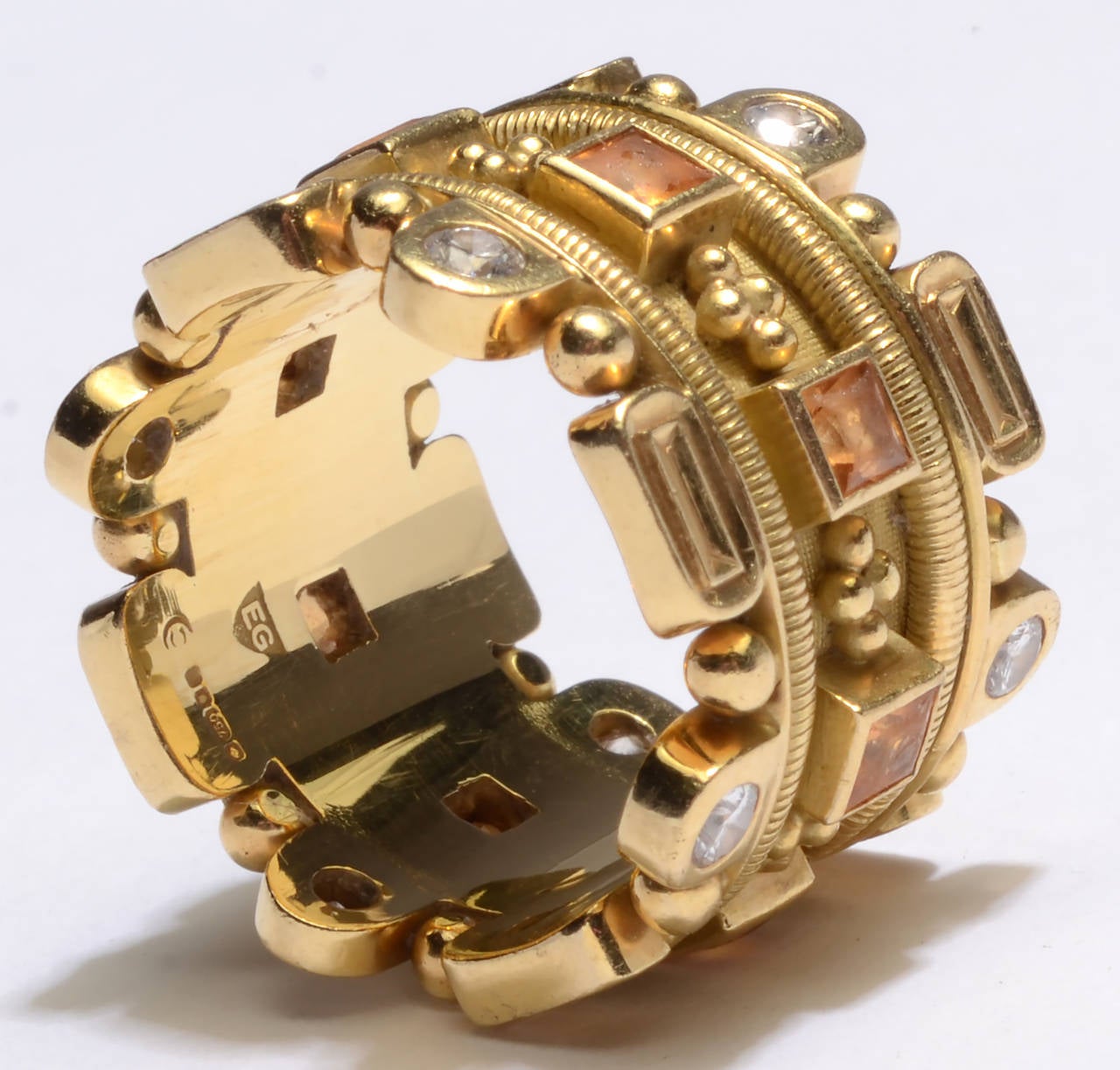 This gold band ring by Elizabeth Gage is especially heavy and complex. It combines round diamonds and square citrines with  balls and ovals of gold. It measures 5/8