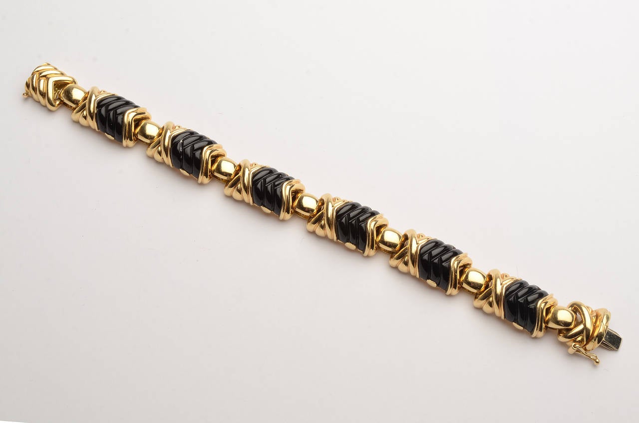 Carved onyx chevrons alternate with X's in this 18 karat gold bracelet by New York jeweler, H. Gold. 
It measures 7 1/4