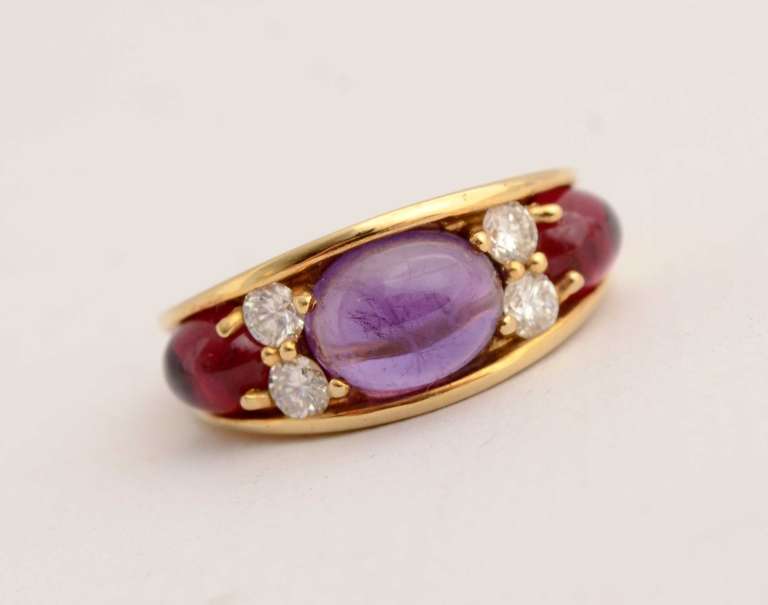 Tiffany 18 karat gold ring with a central amethyst cabochon weighing approximately 2 carats. Four round brilliant diamonds on either side weigh approximately .5 carats. The two rubellite cabochons weigh approximately 2.5 carats. The ring is size 5