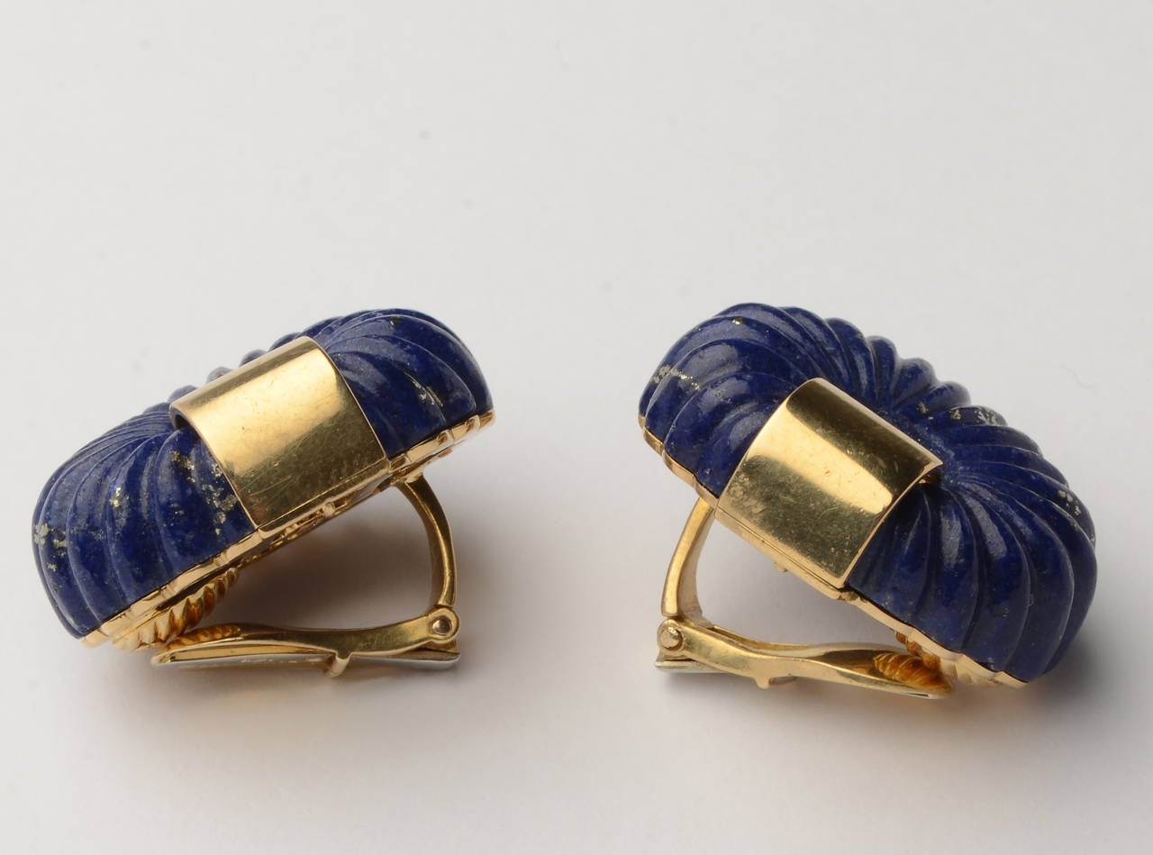Sporty and sophisticated 18 karat gold and lapis lazuli earrings by David Webb. The oval stones are ribbed throughout. They measure 7/8