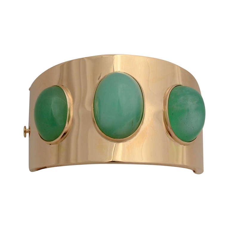 Striking hinged 14 karat gold bracelet with three large chrysoprase oval stones. The largest measures 3 centimeters x 2 centimeters. The front of the bracelet is 1 1/2