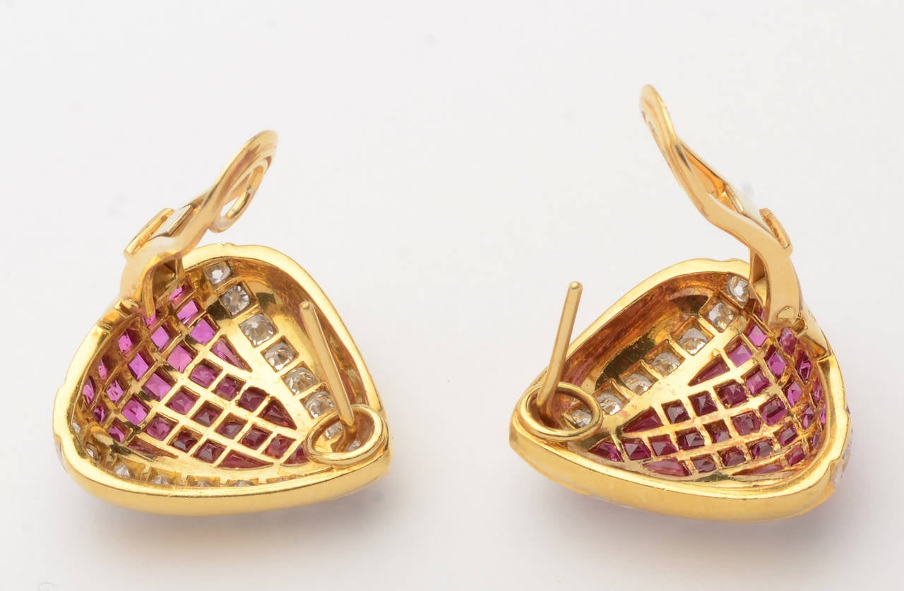 Triangular earrings with 34 brilliant cut diamonds weighing 2 carats surrounding 62 rubies weighing 2.25 carats. Set in 18 karat gold. Omega backs.