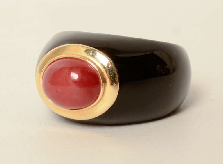 Lovely domed ring of onyx centered with an oval carnelian set in 14 karat gold. The ring is size 6 1/2.