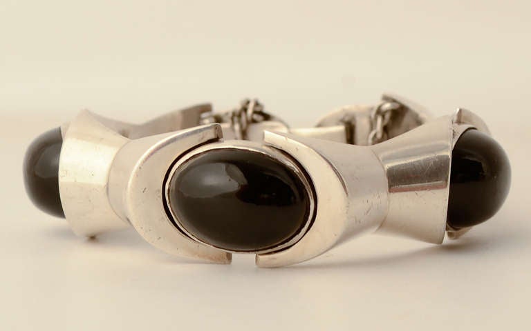 This sterling silver an onyx bracelet is a rare and early example of the work of silver master, Antonio Pineda. The hallmark dates between 1949 and 1953 when he used the name Jewels by Anntonio. It foreshadows the industrial designs often seen in