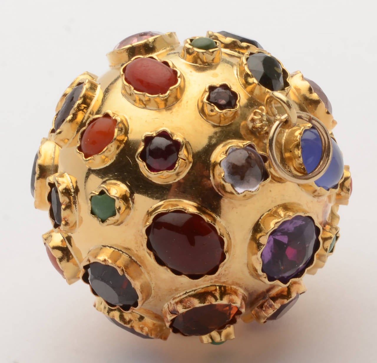 Wonderful, unusual gold ball pendant encrusted with semiprecious stones to include: carnelian; amethyst; turquoise garnet and topaz. The stones are irregular in size and shape; both cabochon and faceted. The 18 karat ball is 
1 1/2