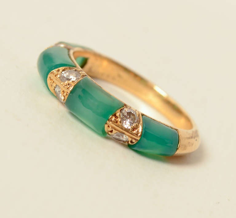 Fine 18 karat gold ring by Boucheron, in which four groups of  jadeite are separated by three groups of two diamonds. Rich in color. Size 6 can easily be sized up or down. French maker's  marks see on outside if shank.