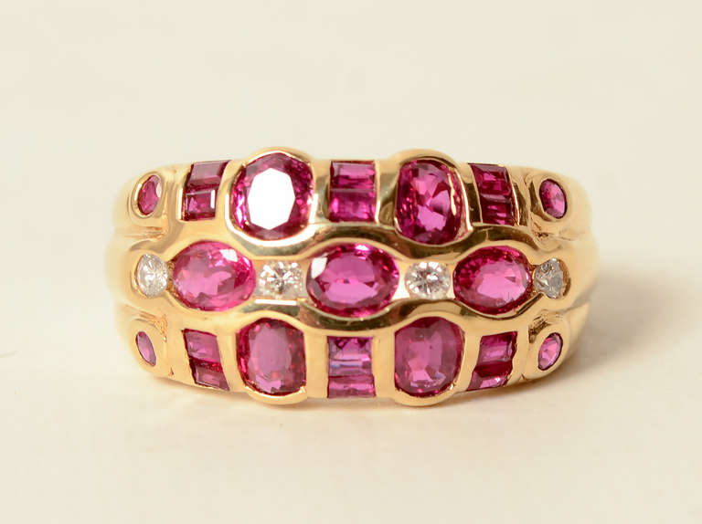 Four diamonds are set among round, square and oval rubies in this unusual  ring. It is 18 karat gold. The front is 7/16