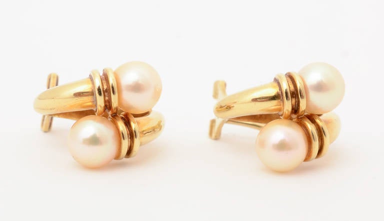 Eighteen karat gold with pearl crossover earrings. They measure 11/16