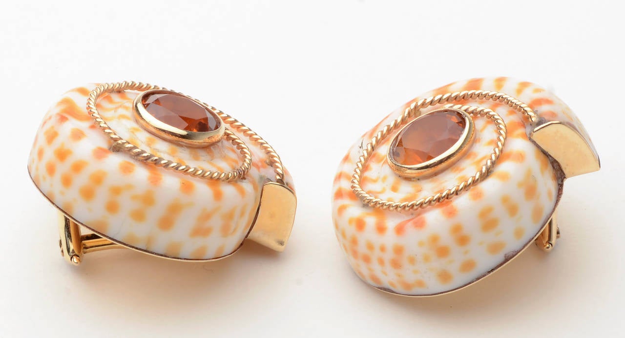 Playful shell earrings centered with citrines. The coil of each shell terminates in a different direction to give a bit of whimsy. Backs are clips. Made by MAZ; circa 1980.