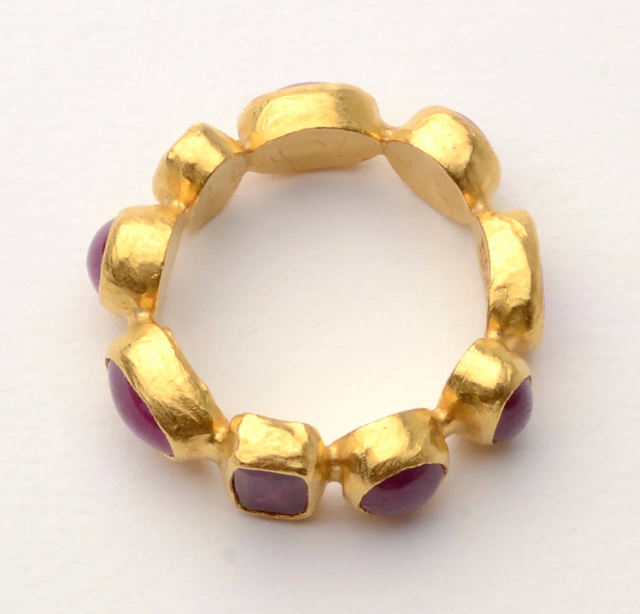 Handmade gold band ring by Gurhan from his Amulet collection. The ring has  nine rubies, both faceted and cabochon, that are round, oval and square. The ring is size 7. It is perfect on its own or can be stacked with other rings. Made of Gurhan's