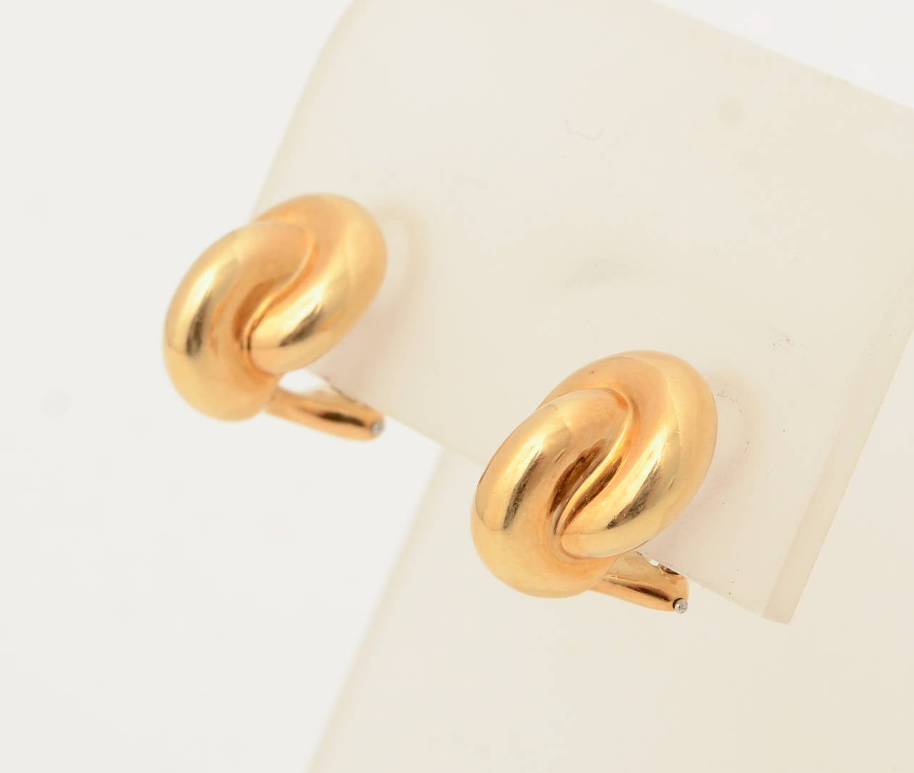 Small 18 karat gold earring by American designer, Angela Cummings. Two ovals intertwine at right angles. They measure 7/16