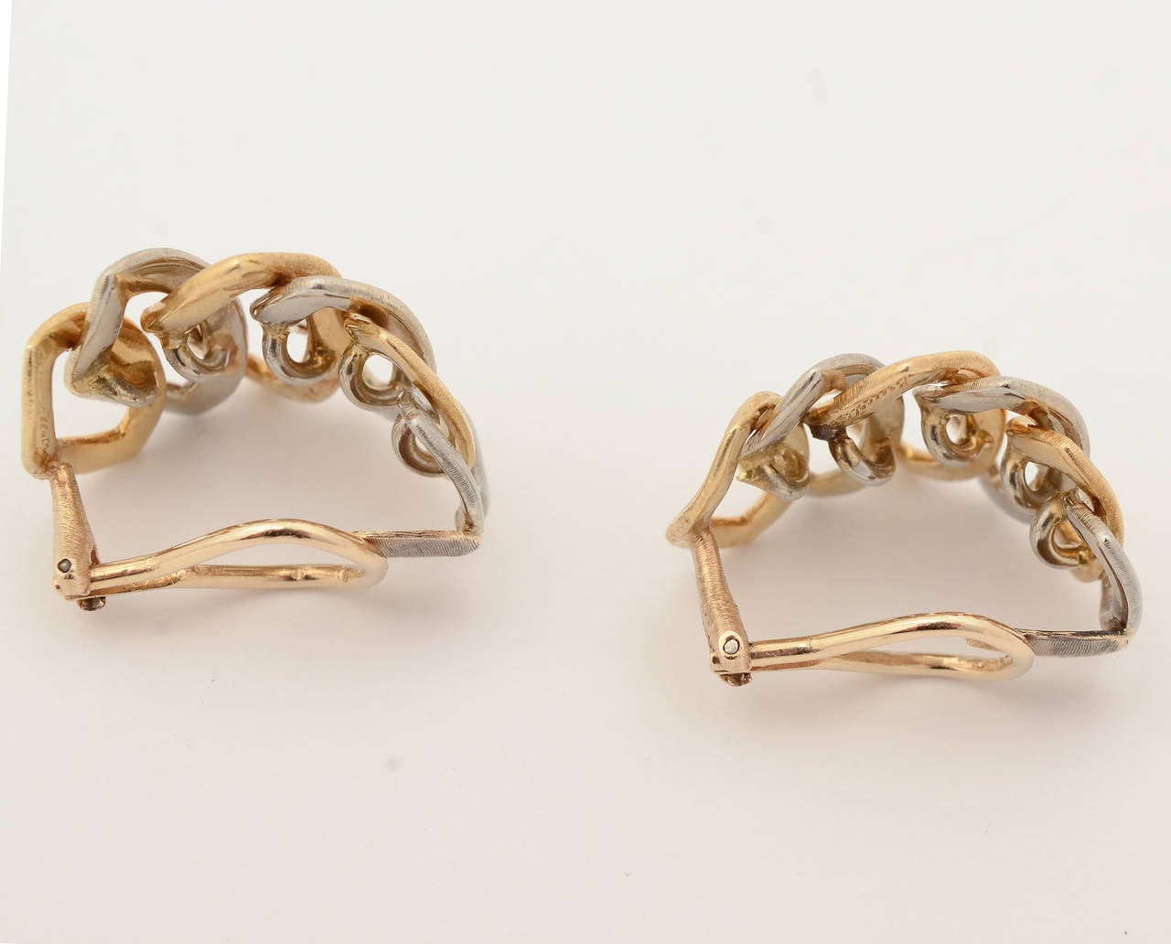 Lozenge shaped links  combine to form hoops in these wonderful Buccellati earrings. They are alternating yellow and white gold. Clip backs. Measurements are1" in length and 13/16" width.