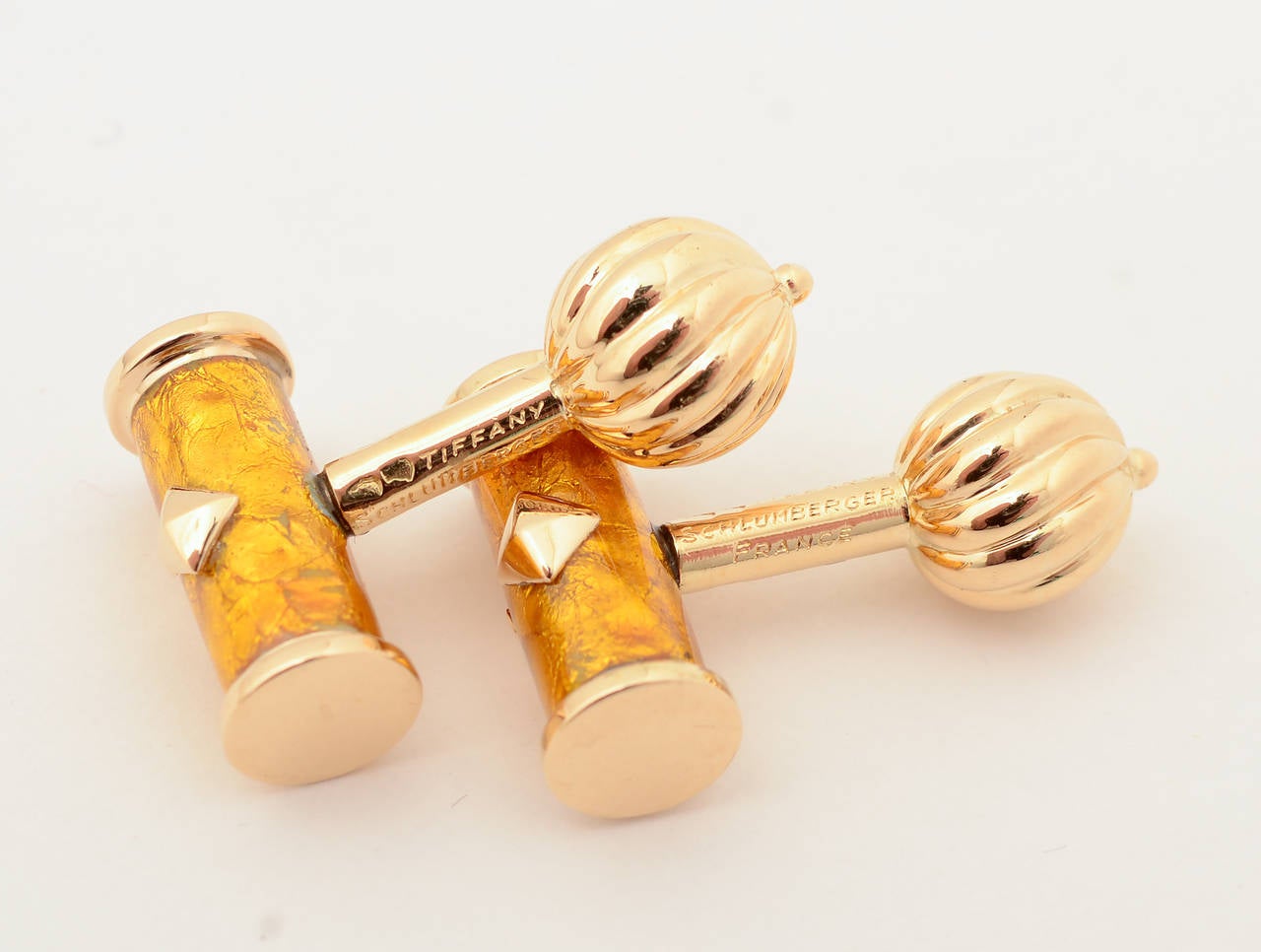 Elegant gold colored enamel cufflinks by Schlumberger. The barrel shaped front is backed with a swirling, striated ball. The barrel measures 11/16