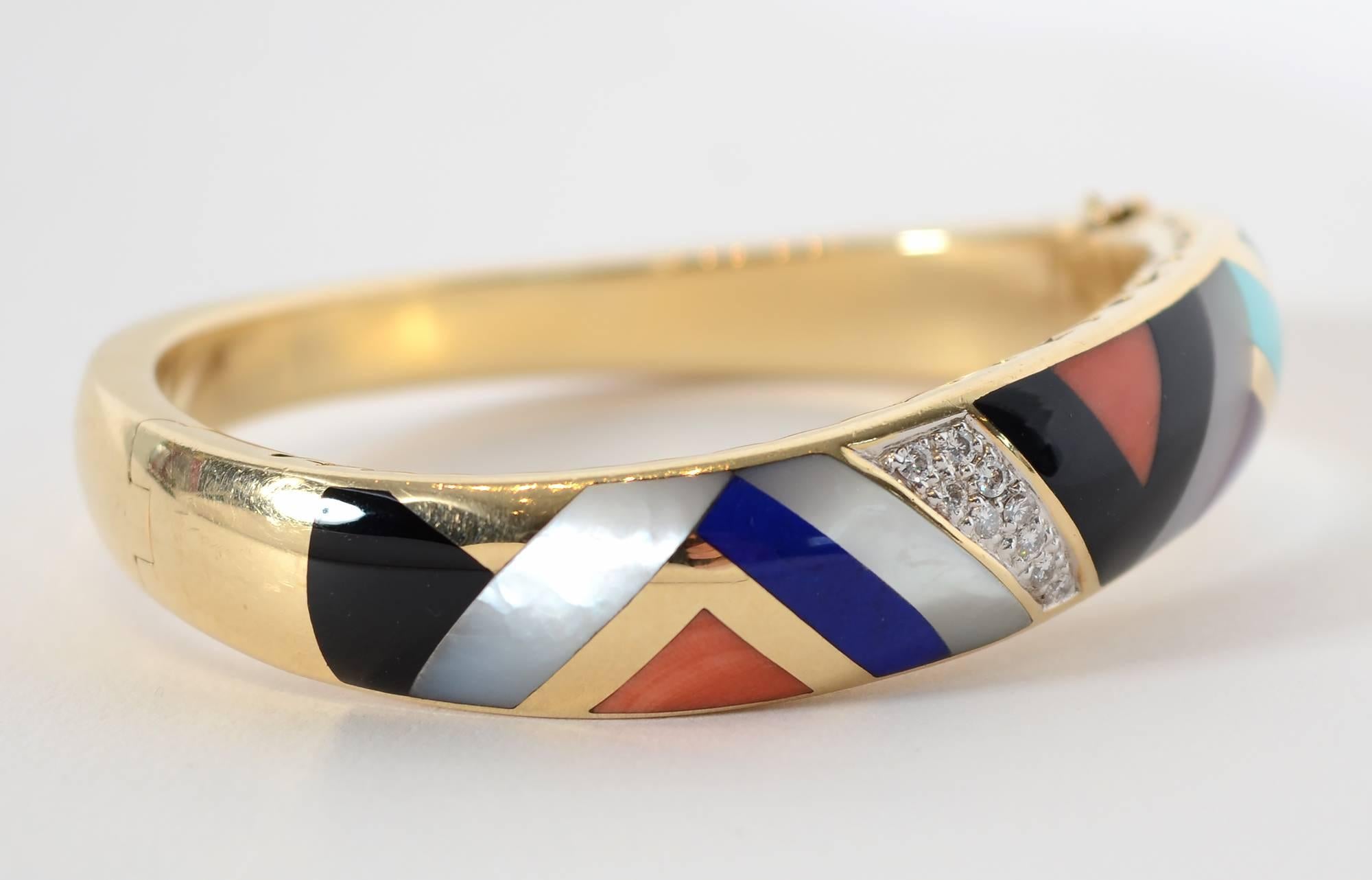 Chevron pattern bracelet by Asch Grossbardt in which the entire bracelet is an undulating form. The inlaid multicolored stones include black onyx; mother of pearl; coral; turquoise; malachite and diamonds. The gold sides of the bracelet have cutout