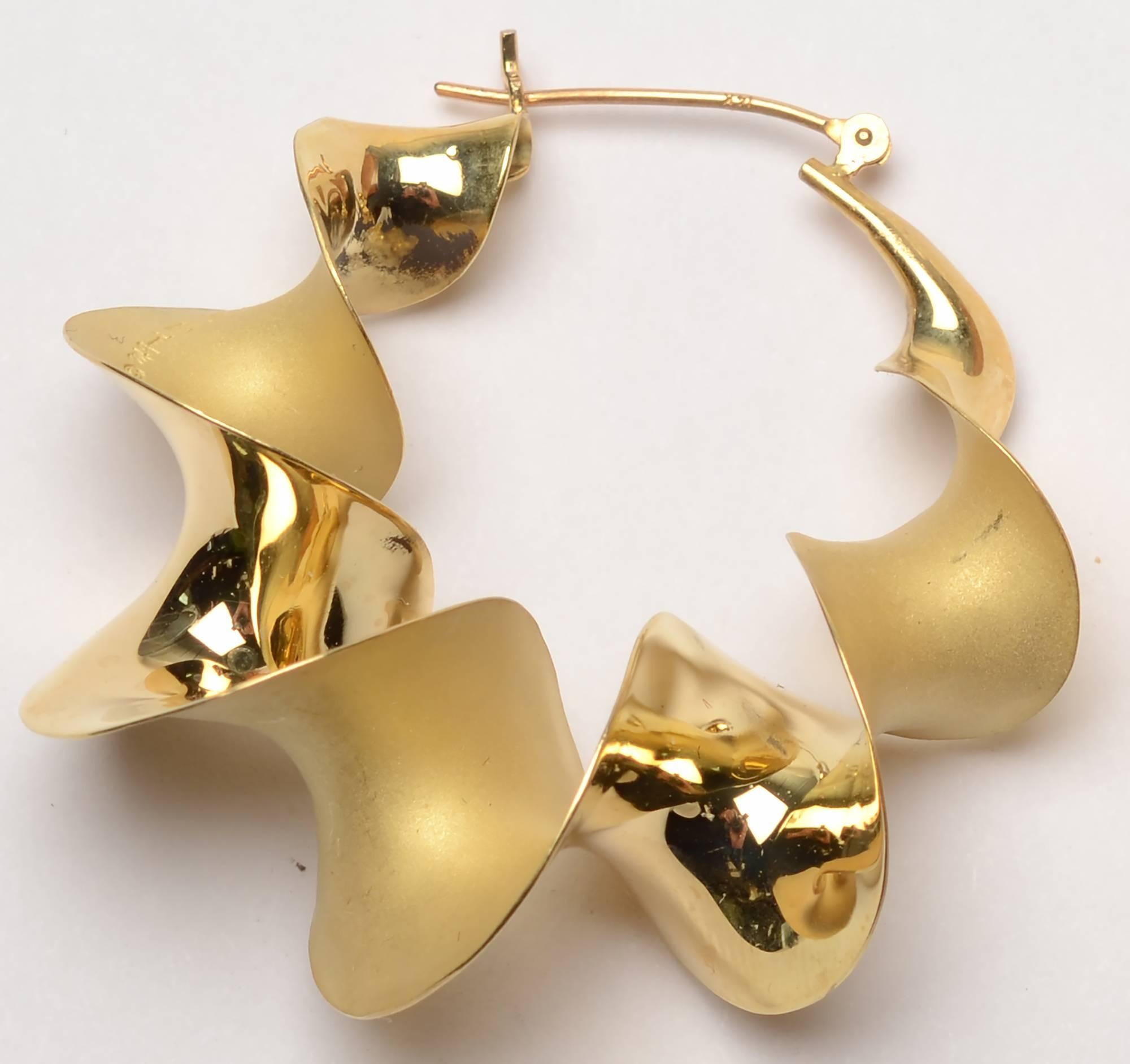 Michael Good is known for his very sculptural jewelry and his ability to twist the metal to create new surfaces. In addition to creating new surfaces in these unusual hoop earrings, Good also created two different finishes. The earrings are both