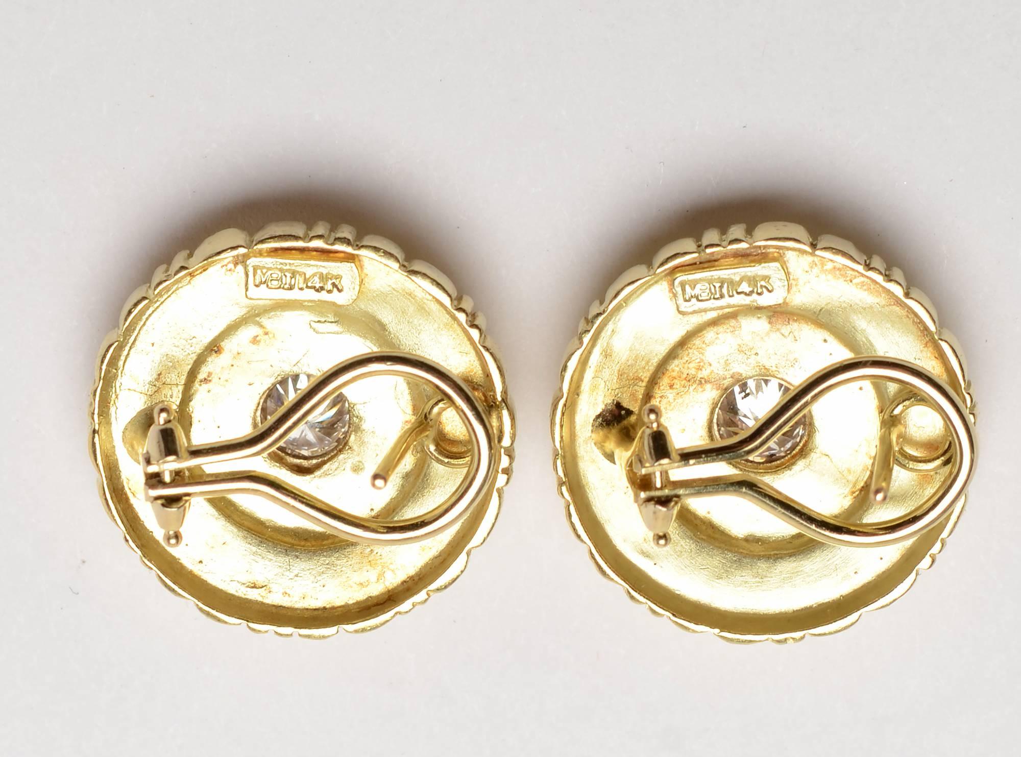 These round gold earrings have a stepped design of rectangles, bars and balls. They radiate from the half carat center diamond. 
Backs are posts and clips. A maker's mark is not quite decipherable. Measurement is 13/16