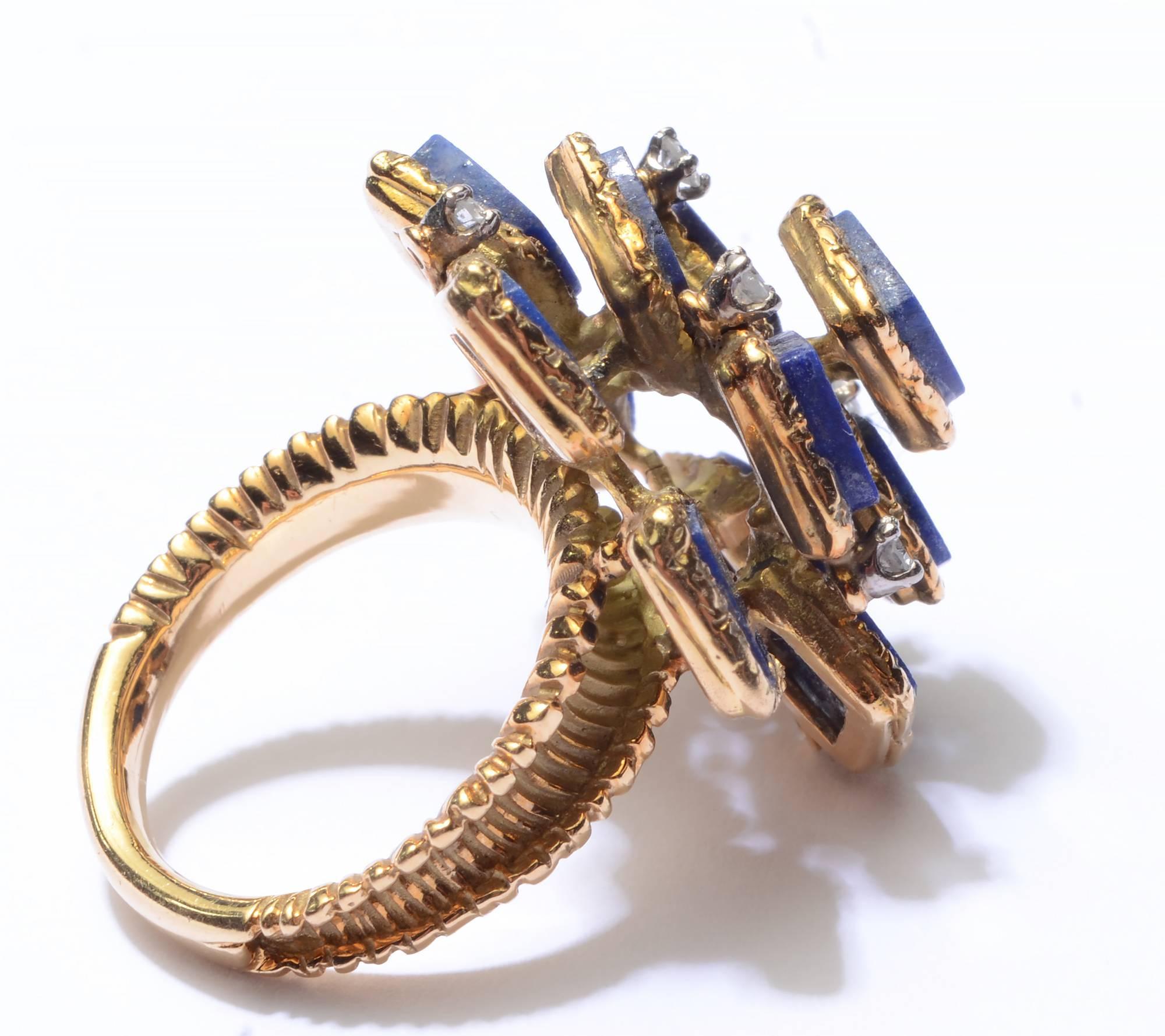 This 18 karat gold ring is set with eleven squares of lapis lazuli in a multi tiered arrangement. Each stone is framed by a textured gold band. In between are 6 diamonds weighing .05 carats each. The ring is size 5 1/4; it can easily be sized up or