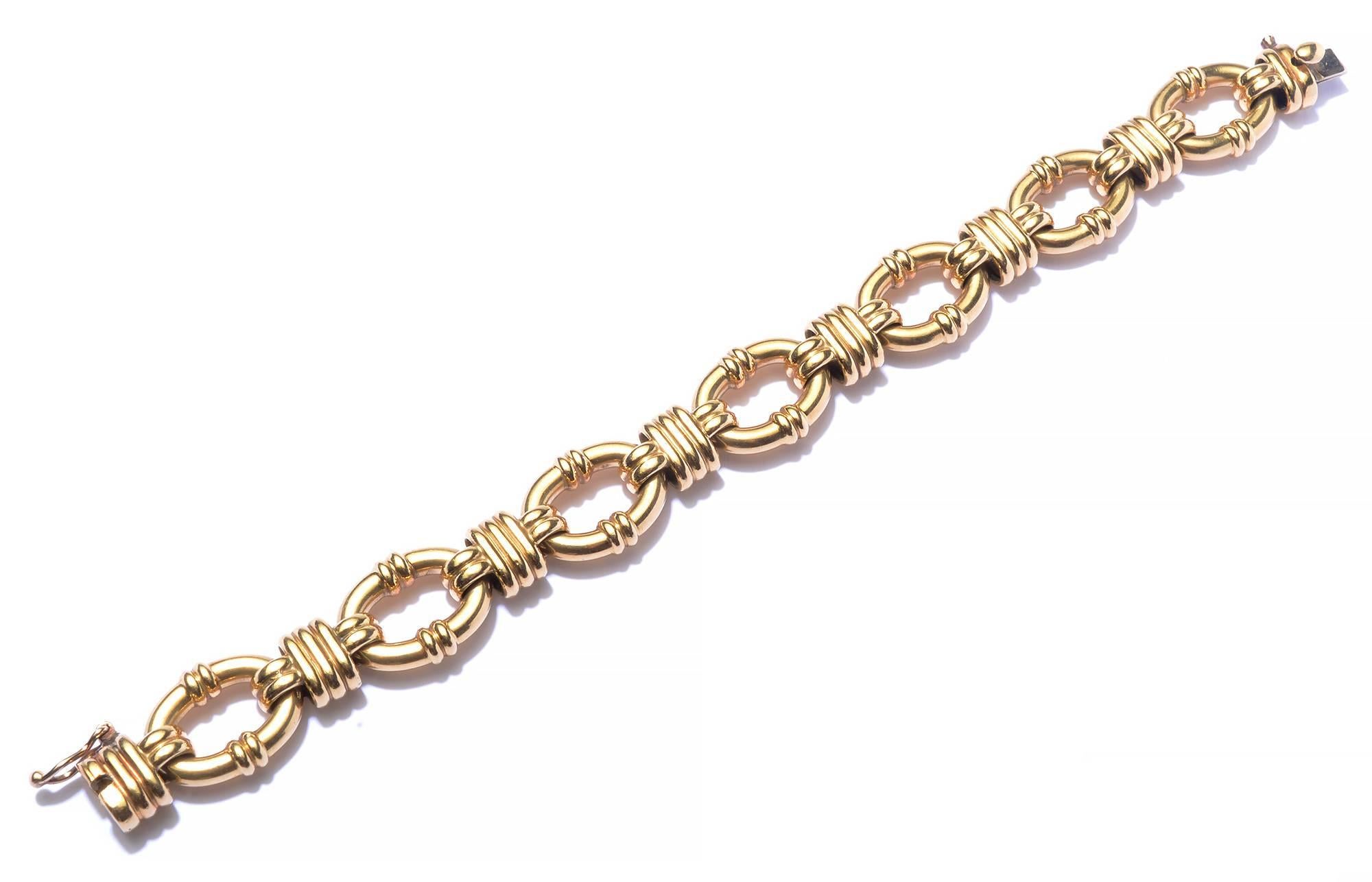 Stylish oval links 18 karat  bracelet by Tiffany and Co. The banding on the links echoes the crisscross design between the ovals. It measures 7 1/4