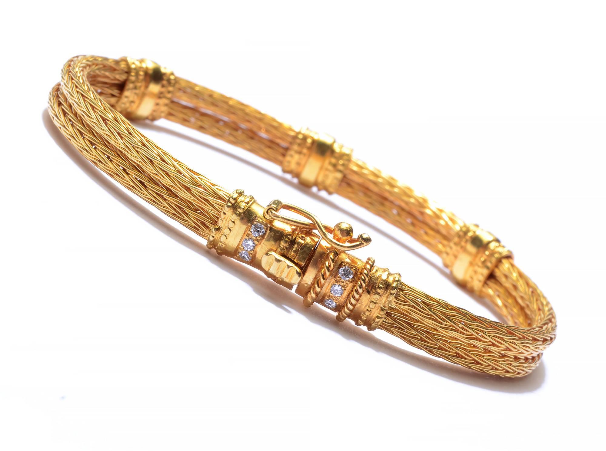 This 18 karat gold bracelet by Ilias laLaounis is elegant and understated. Two rows of foxtail woven gold are joined by five delicately textured bands of gold with diamonds. The bracelet measures 7 1/4