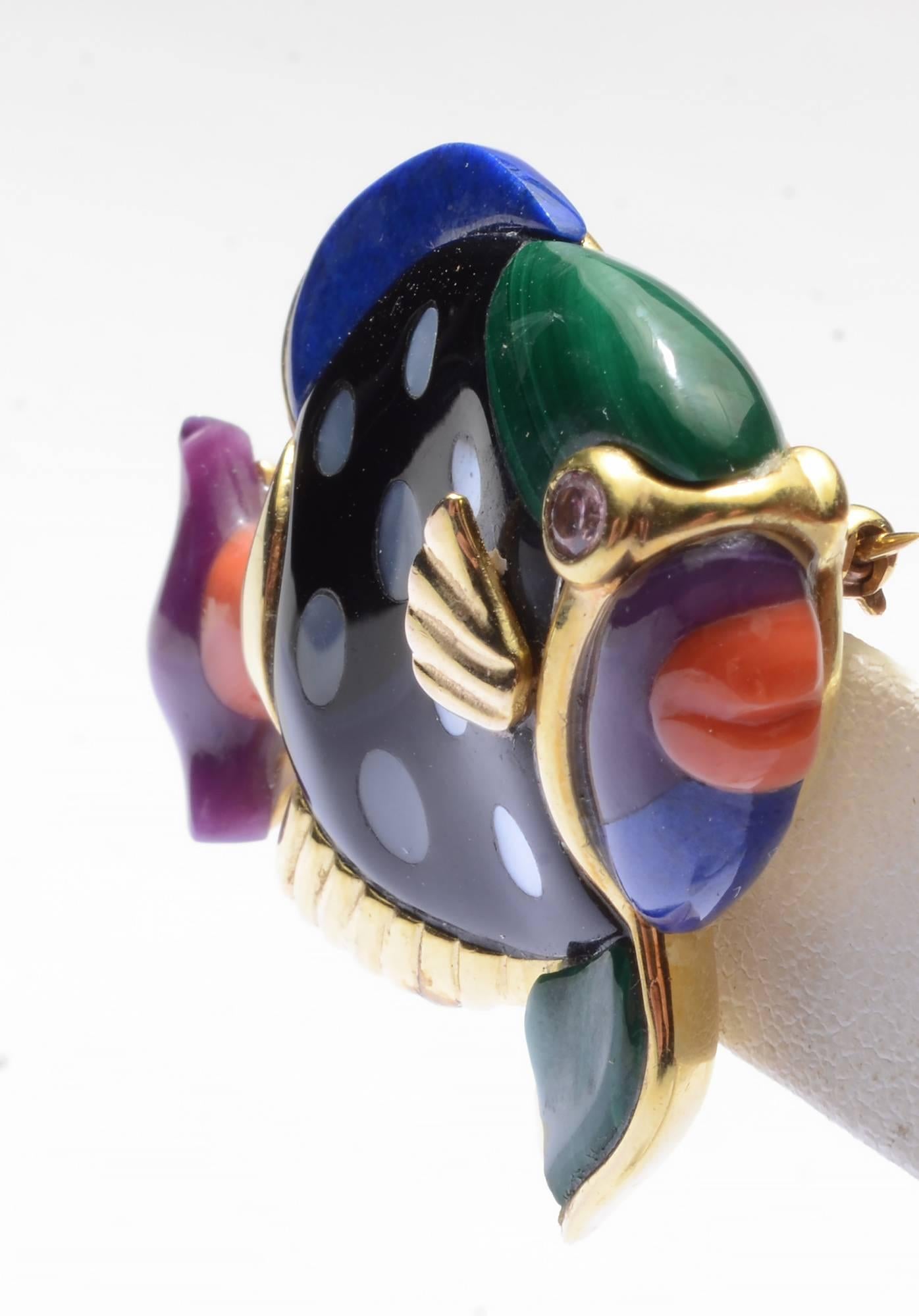 This colorful and whimsical fish brooch by Asch Grossbardt is made with the variety of inlaid stones for which they are known. The body is onyx with irregular polka dots of mother of pearl. Additional stones are: malachite; lapis lazuli; purple