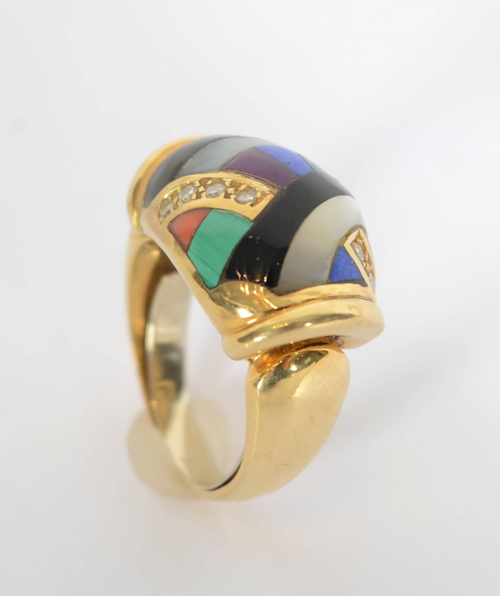 Stylish abstract design ring by Asch Grossbardt with a Deco feel. Inset in the 18 karat gold are: diamonds; lapis lazuli; black onyx; mother of pearl; malachite ; purple sugilite and coral. The dome shaped setting for the stones sits above the band