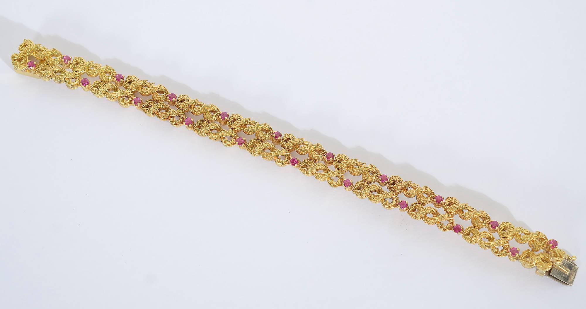 Interwoven loops of textured gold are interspersed with rubies in this refined, elegant Tiffany bracelet.
It measures 7 3/8
