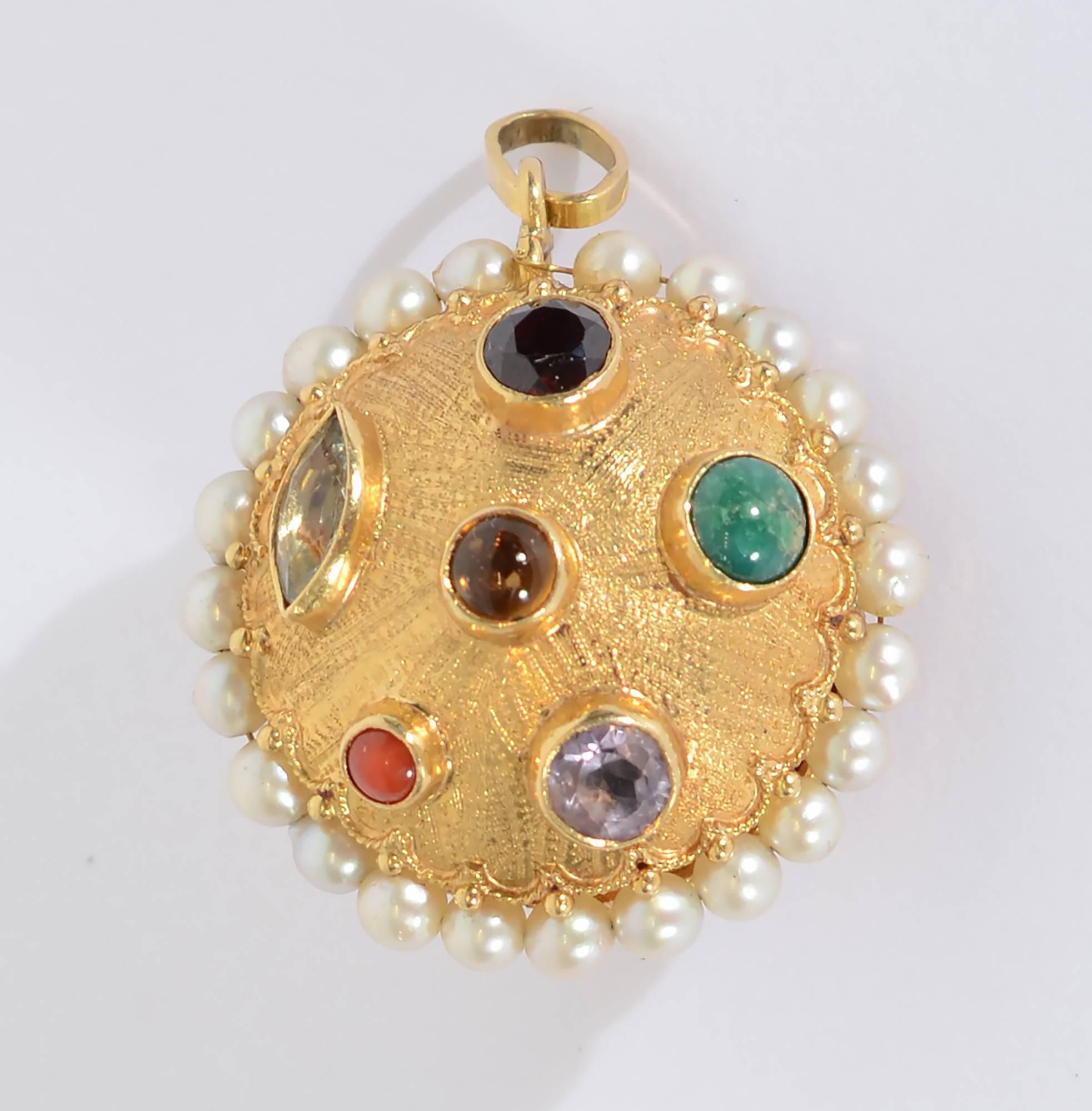 Beautifully made reversible 18 karat  gold domed disc with a variety of semiprecious stones. They include: amethyst; citrine; garnet; coral and turquoise. Stones are both faceted and cabochon. The entire disc is surrounded with a gold swag and a