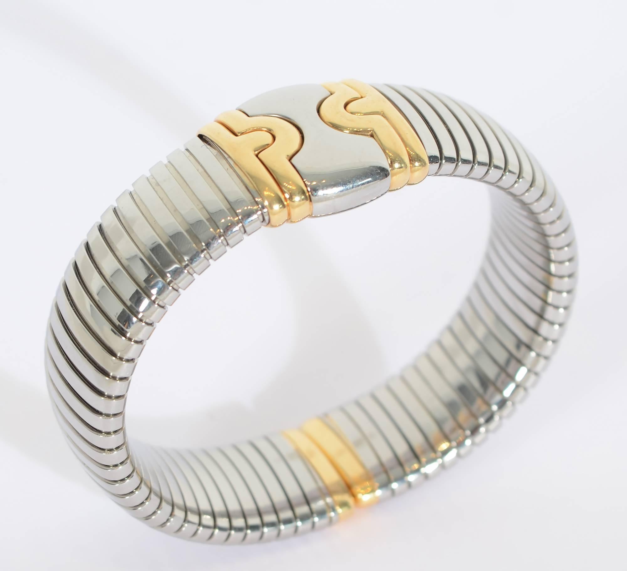 Classic Bulgari tubogas cuff bracelet made of steel with 18 karat gold front medallion and tips. The bracelet is 8  3/8
