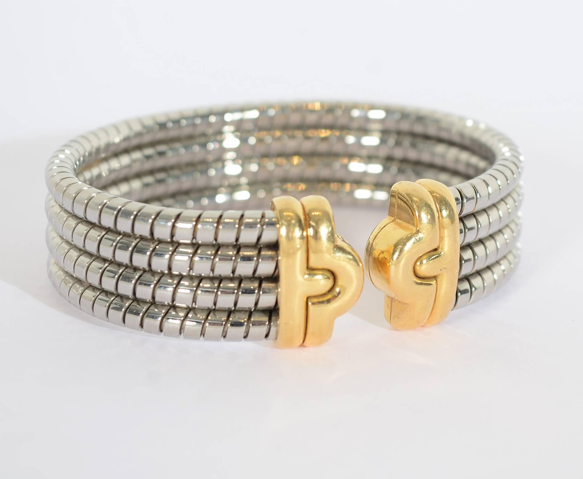 Classic Bulgari tubogas cuff bracelet made of steel with 18 karat gold front medallion and tips. The bracelet is 3/4