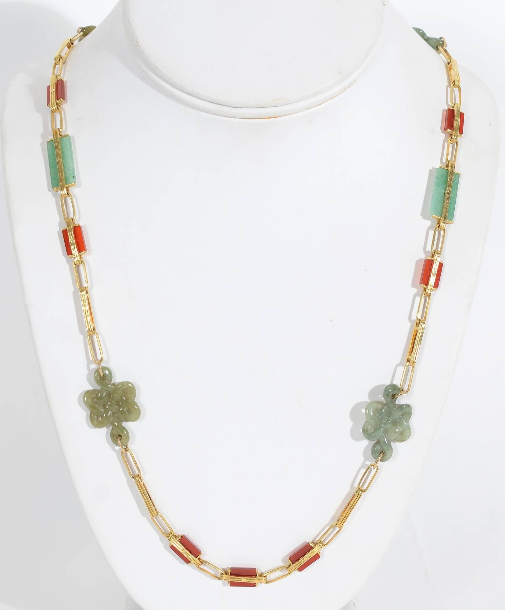 Unusual gold with carnelian and jade necklace. The elongated gold links alternate with rectangles of the two stones. Four lacy carved medallions of jade are a wonderful contrast to the geometric shapes. The necklace measures 33 inches in length. The