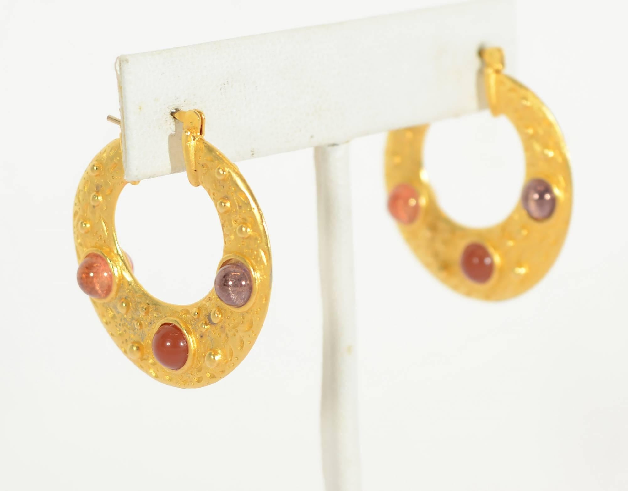 Beautifully textured 22 karat gold hoop earrings with three inlaid stones. Carnelian is in the center and quartz on either side. The hoops measure 1 1/8