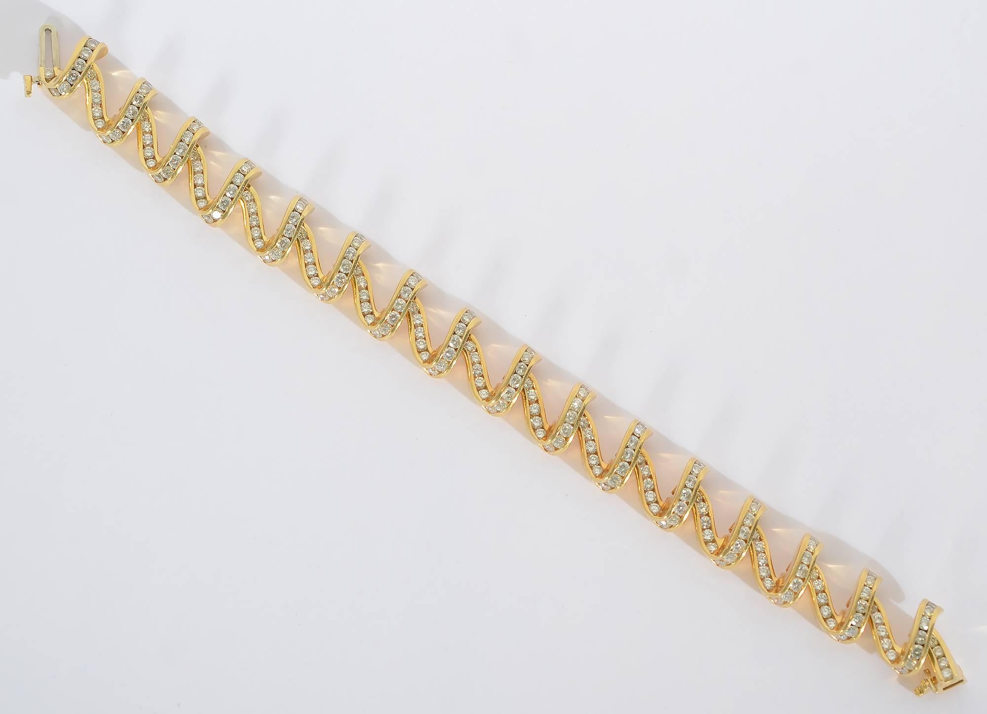 This exquisite bracelet by Charles Krypell looks like undulating ribbon. It has wonderful grace and dimensionality.The links are filled with 9 carats of round-faceted diamonds. The bracelet measures 7 inches long and 1/2 an inch wide. It has a