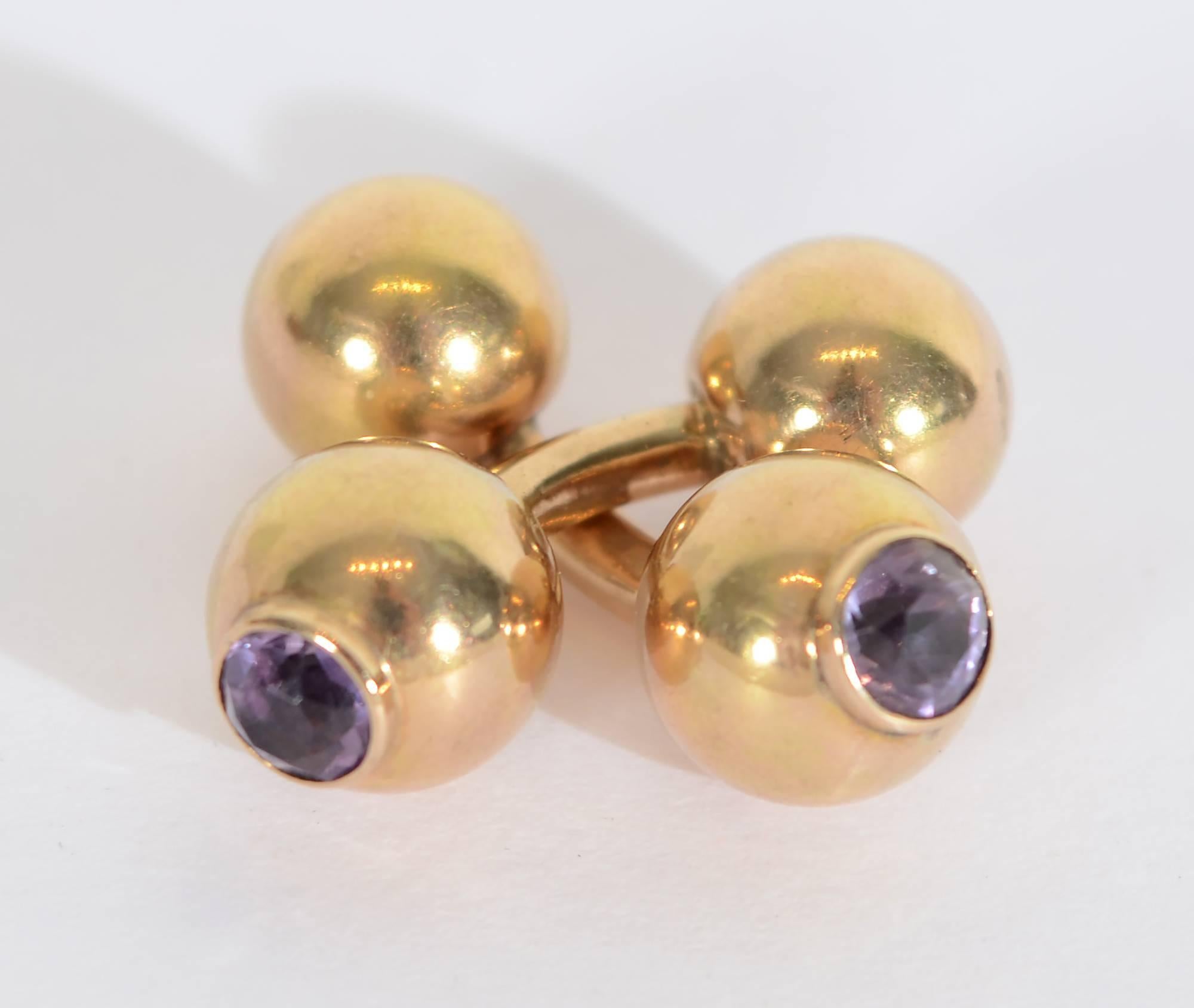Gold double ball cufflinks suitable for either a lady or gentleman. One ball has a faceted amethyst; the other is all gold. Measure 7/8